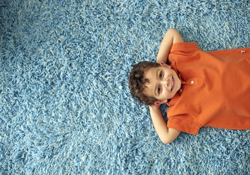 Boy Lying on Carpet --- Image by © Royalty-Free/Corbis